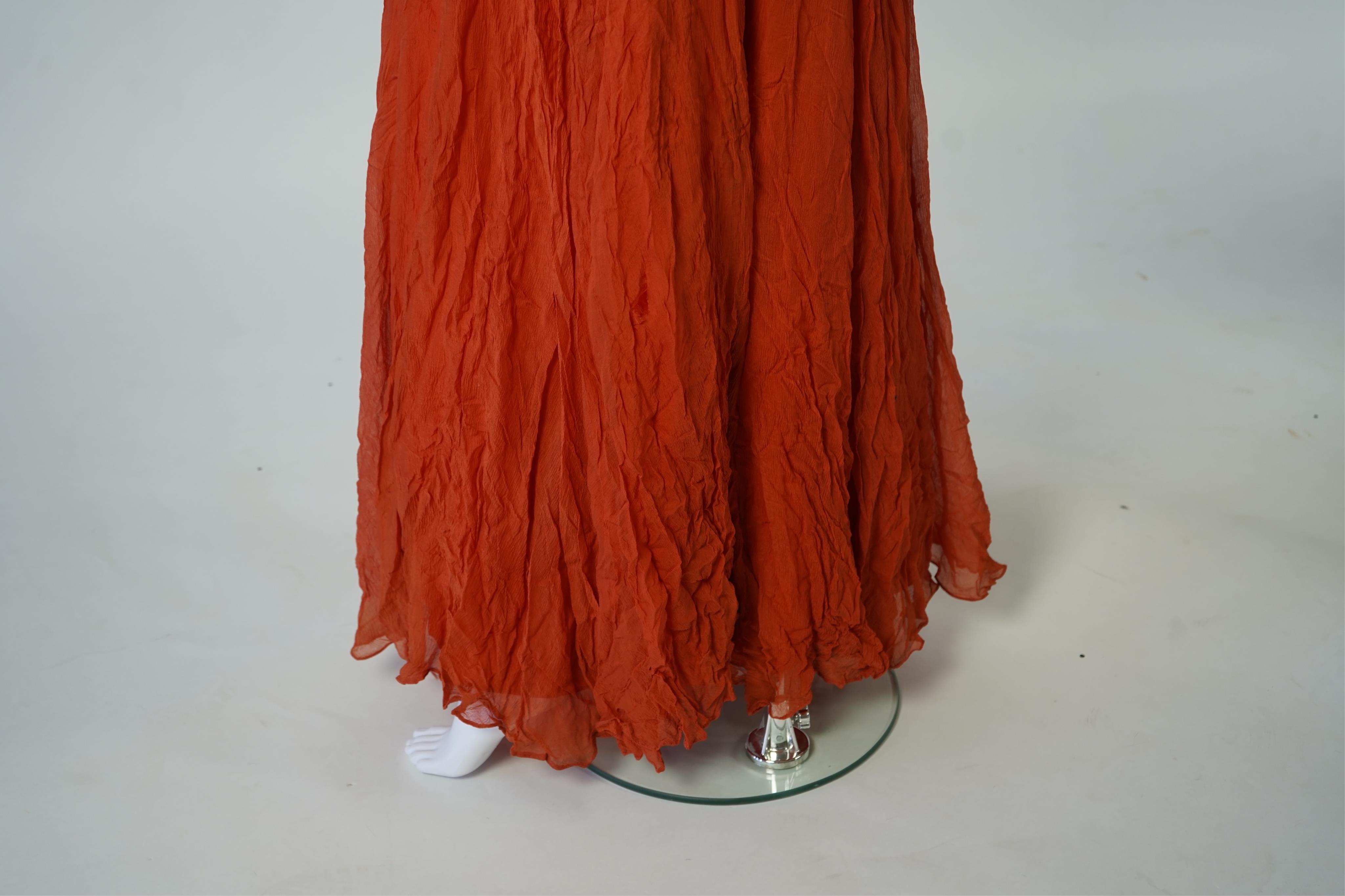 A 1940’s orange chiffon evening dress, with an orange silk taffeta lining, a pleated bodice and front apron panel tied at the back., 156 cm long. Condition - there are a few small holes in the chiffon at the back of the